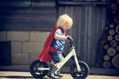 Süper kahraman çocuk binmek bisiklet tarafından