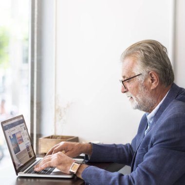 Dizüstü bilgisayar kullanan kıdemli adam.