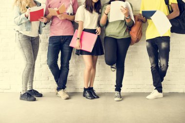 Beyaz duvara karşı ayakta öğrenciler 