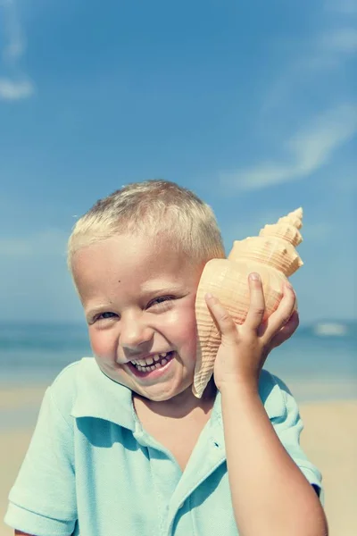 Little Boy escucha shell —  Fotos de Stock