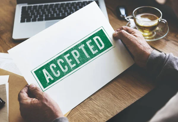 Person holding paper at wooden table — Stock Photo, Image