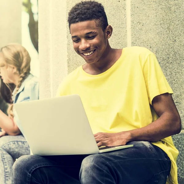 Afrikaanse student met behulp van laptop in straat — Stockfoto