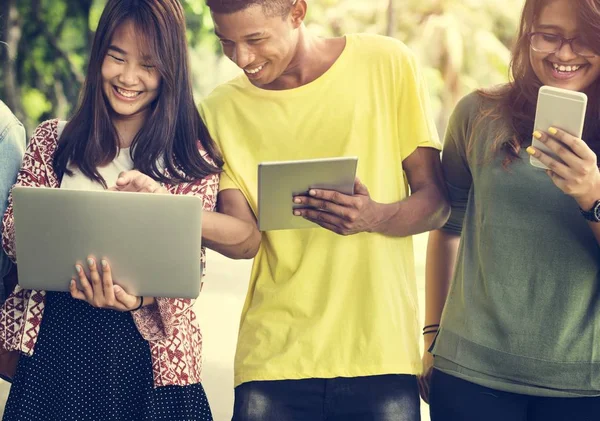 Vrienden lopen en het gebruik van digitale apparaten — Stockfoto