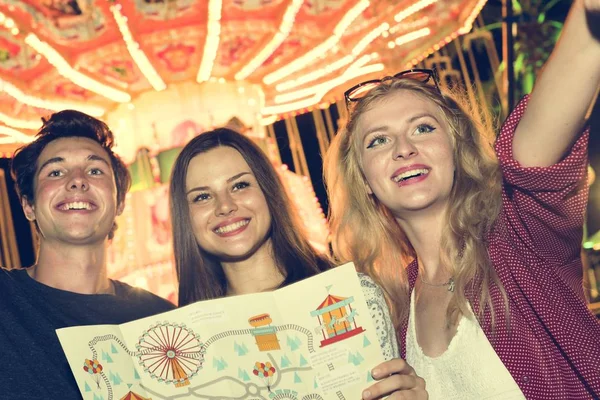 Vrienden in attractiepark met kaart — Stockfoto