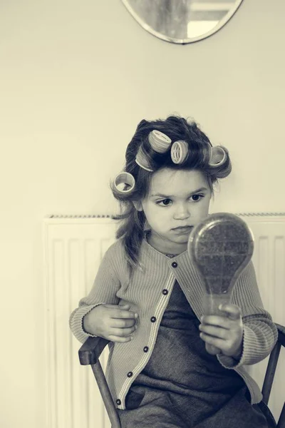 Маленькая девочка с бигуди на волосах — стоковое фото