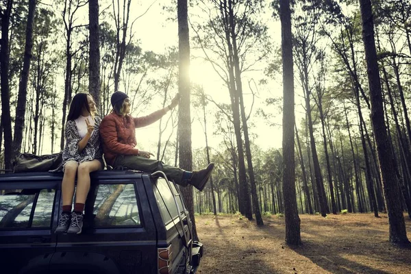 Casal sentado no carro na floresta — Fotografia de Stock