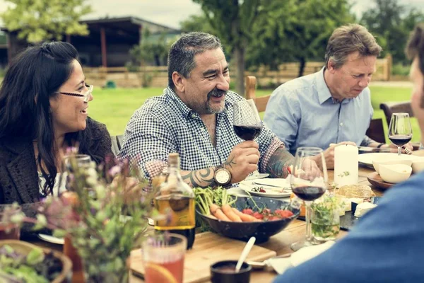 Groep van mensen eten buitenshuis — Stockfoto