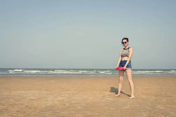 Mädchen spielt Frisbee am Strand — Stockfoto