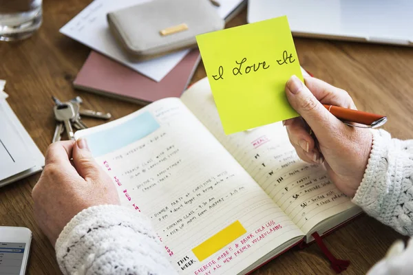 Persona sosteniendo nota de palo amarillo — Foto de Stock