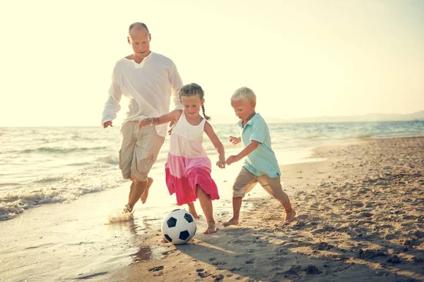Familie spielt Fußball am Strand — Stockfoto