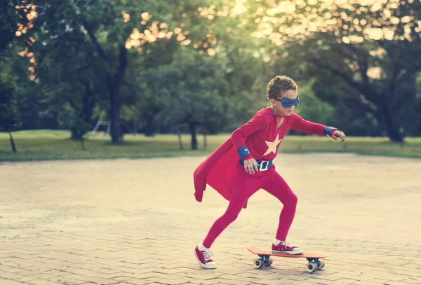 Superherou chlapec jízda na skateboardu — Stock fotografie