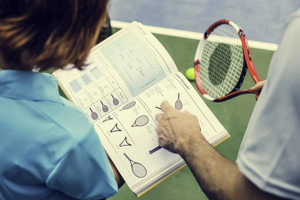 Mädchen und Trainer lesen Tennisbuch — Stockfoto