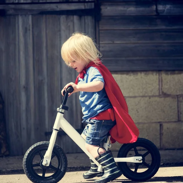 Supereroe ragazzo giro in bicicletta — Foto Stock