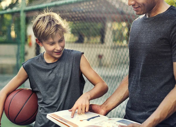 Hombre y niño aprendiendo a jugar al baloncesto — Foto de Stock