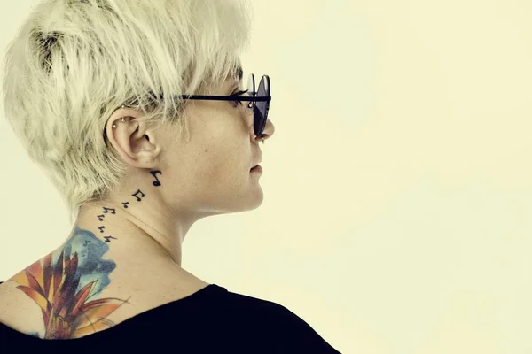 Жінка з татуюваннями позує в студії — стокове фото