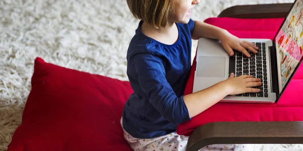 Petite fille en lunettes à l'aide d'un ordinateur portable — Photo