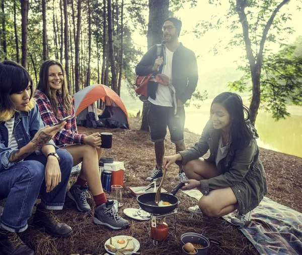 Amigos comendo alimentos no acampamento — Fotografia de Stock