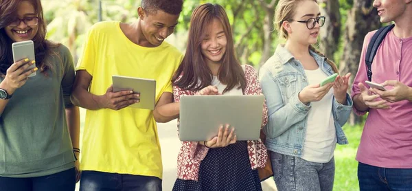 Vrienden lopen en het gebruik van digitale apparaten — Stockfoto