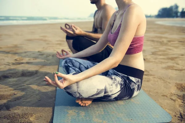 Koppel doen yoga op het strand — Stockfoto