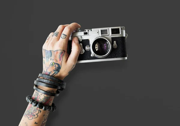 Χέρι στα τατουάζ κρατά φωτογραφική μηχανή φωτογραφιών — Φωτογραφία Αρχείου
