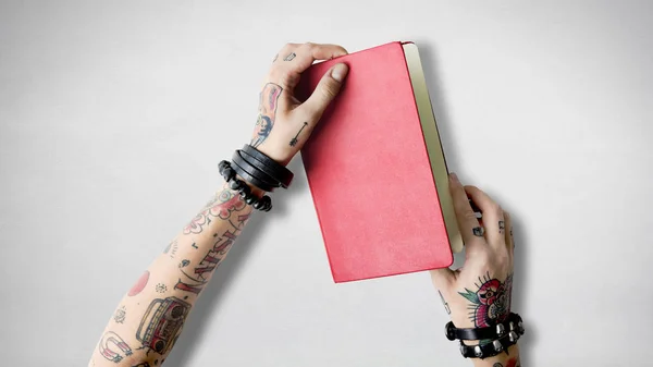 Notebook in hands in tattoos — Stock Photo, Image