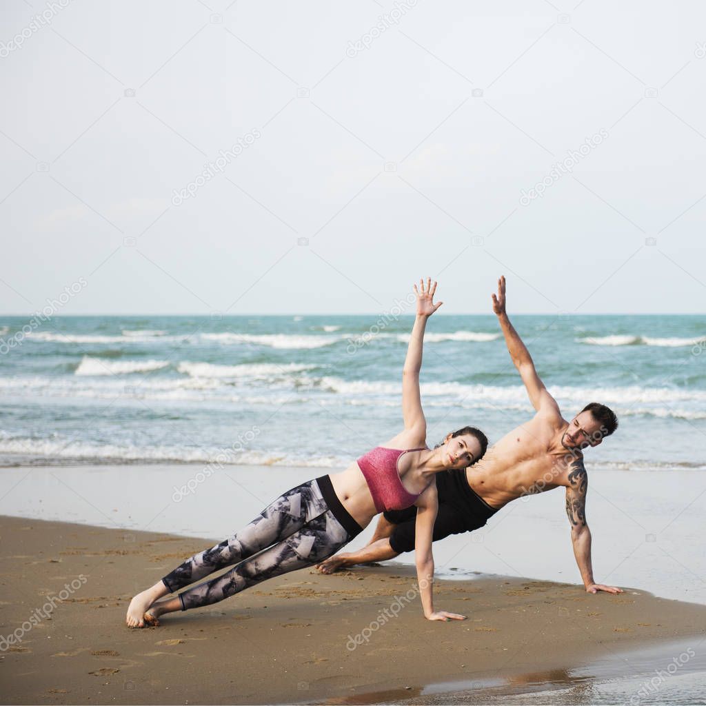 Couple doing Yoga on Beach