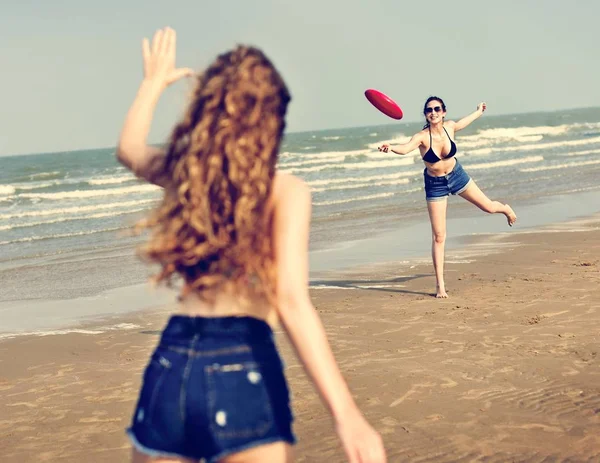 Chicas jugando frisbee en la playa —  Fotos de Stock