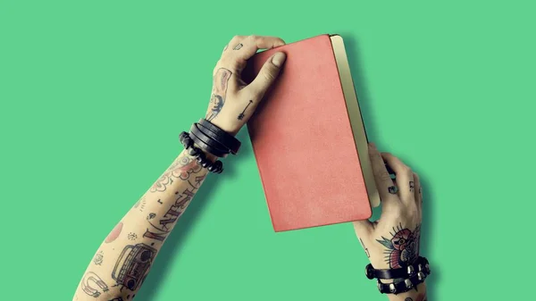 Notebook in hands in tattoos — Stock Photo, Image