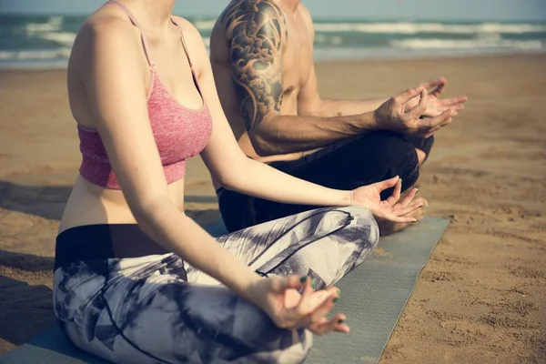 Çiftler plajda yoga yapıyor. — Stok fotoğraf