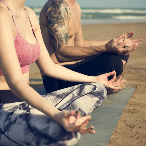 Casal fazendo ioga na praia — Fotografia de Stock