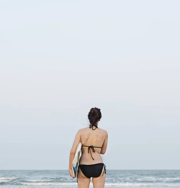 Mujer con tabla de surf en la playa —  Fotos de Stock