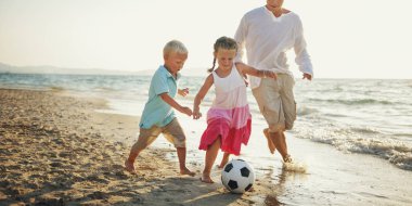 Kumsalda futbol oynarken aile