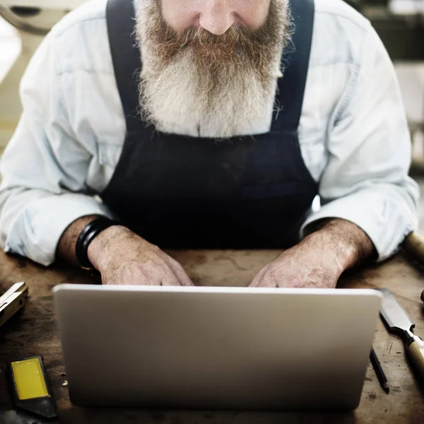 Майстер використовує ноутбук у майстерні — стокове фото