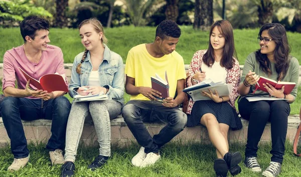 Diverse studenten zitten in het park — Stockfoto
