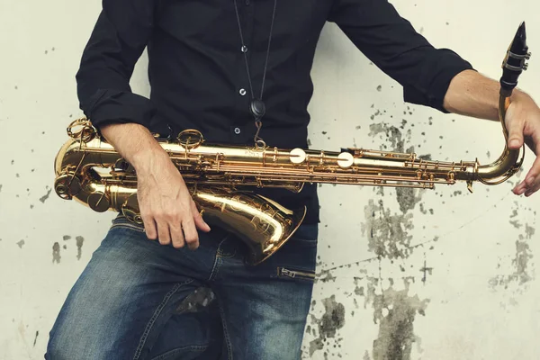 Джаззман держит саксофон — стоковое фото