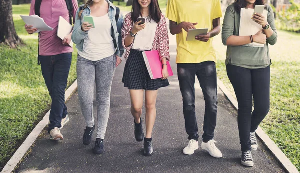 Vänner promenader och använder digitala enheter — Stockfoto