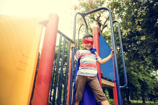 Мальчик на детской площадке во дворе — стоковое фото