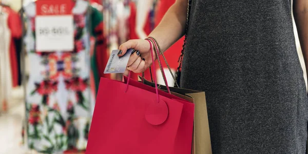Kvinna med shoppingväskor och kreditkort — Stockfoto