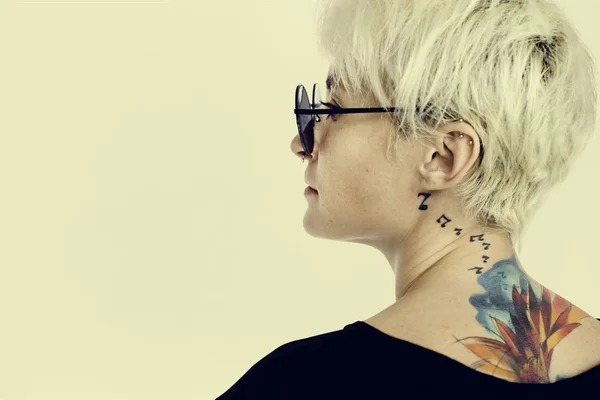 Kvinna med tatueringar poserar i studio — Stockfoto