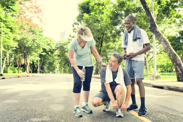 Amigos seniores fazendo jogging no parque — Fotografia de Stock