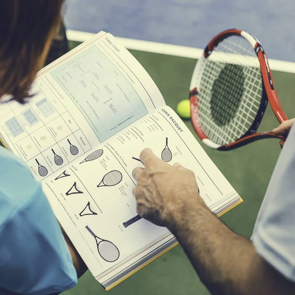 Chica y entrenador leyendo libro de tenis — Foto de Stock