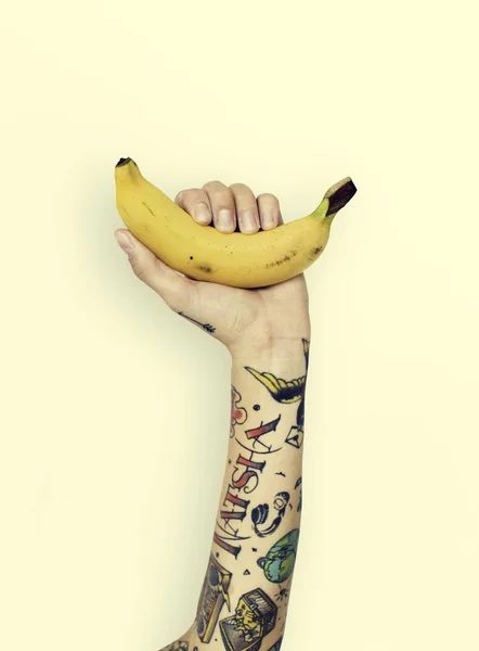 Tetoválás kéz tartja a banán — Stock Fotó