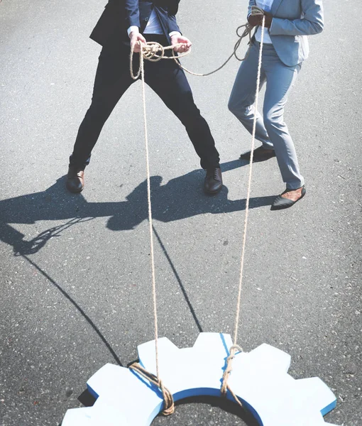 Business people pulling gear — Stock Photo, Image