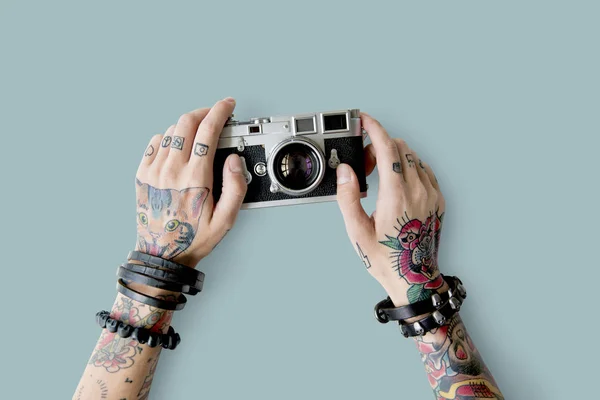 Manos en tatuajes sostiene cámara fotográfica — Foto de Stock