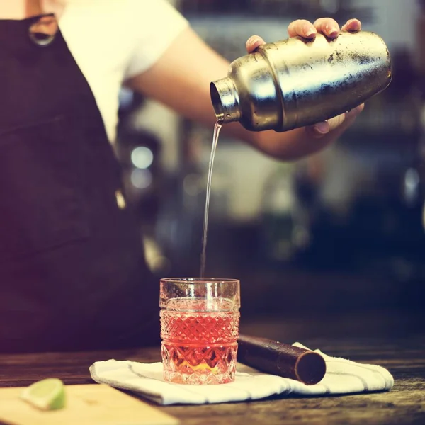 Barista pouring cocktail in glass — Stock Photo, Image