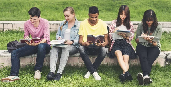 Olika studenter sitta på park — Stockfoto