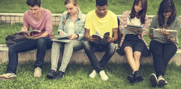 Diverse students sit at park — Stock Photo, Image