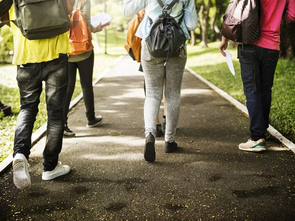 Los estudiantes van a la universidad al otro lado del parque —  Fotos de Stock