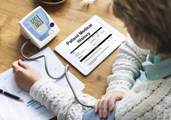 Frau überprüft Blutdruck — Stockfoto