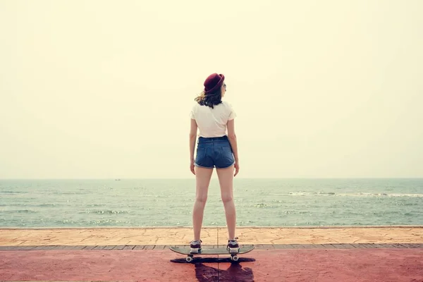 Дівчина в шортах скаче скейтборд — стокове фото